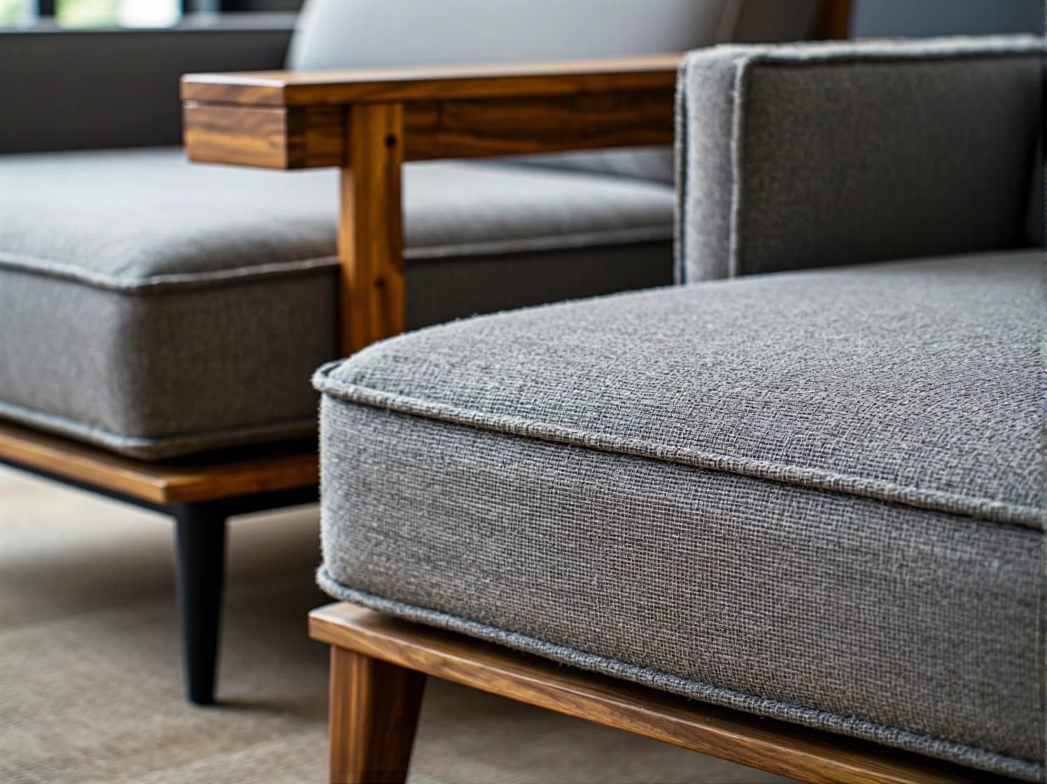 Szara sofa tapicerowana na drewnianej ramie orzechowej